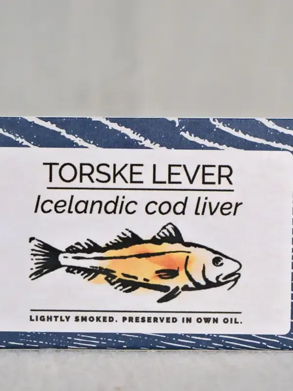 Boks med lettrøkt islandsk torskelever fra Fangst, servert med toast og sitronskiver på et trebord.