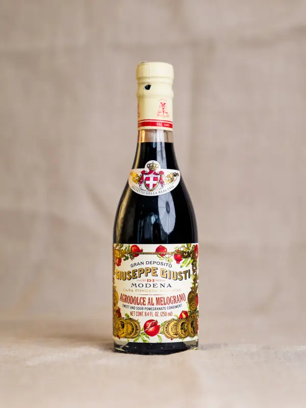Flaske med Giusti Agrodolce al Melograno (250 ml) – elegant italiensk frukteddik med granateple. Ideell til salater, marinader og cocktails.