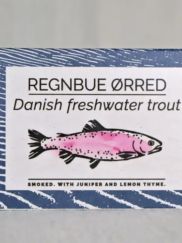 Boks med lettrøykt regnbueørret fra Fangst, servert med sitronskiver og friske urter på et trebord.